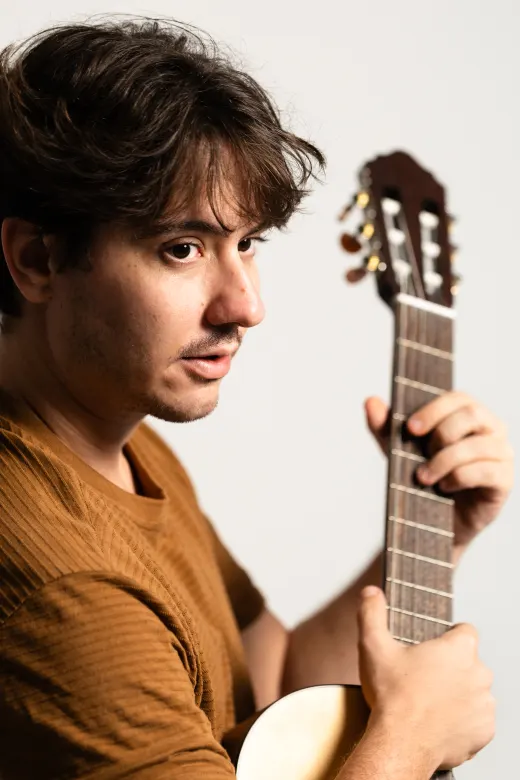 Leonel com o violão, em close